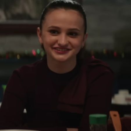 Ava Russo is sitting at the dining table smiling.